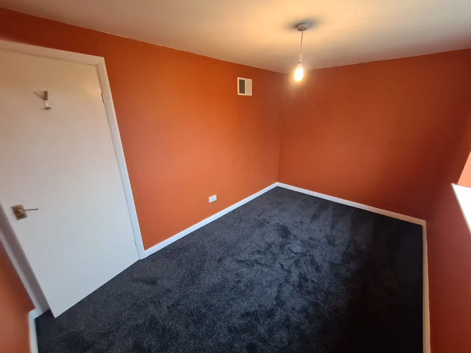 Bedroom repainted in a burnt orange feature colour