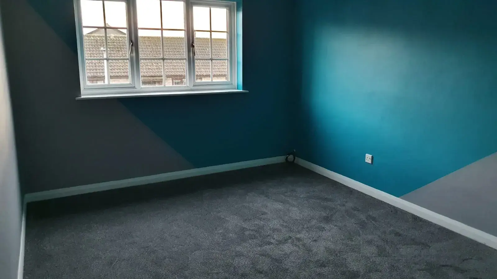 Bedroom decorated with teal and grey geometric feature walls