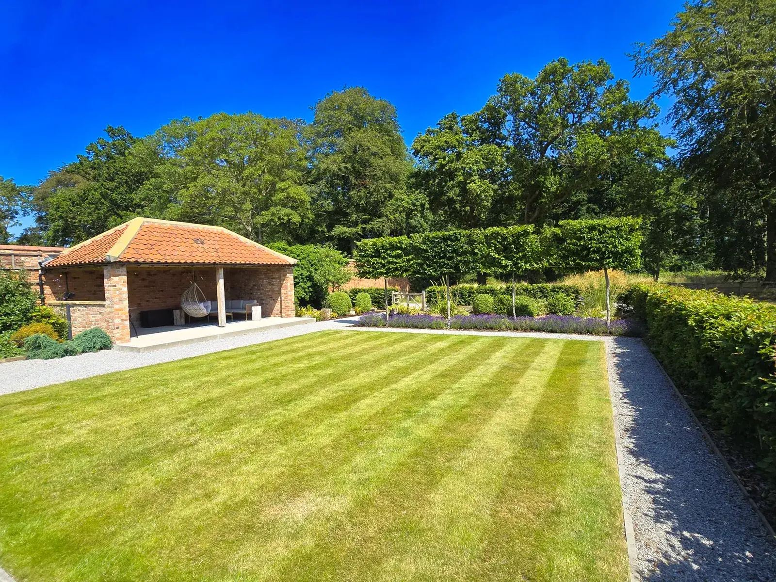 Striped lawn and lavender in a walled garden